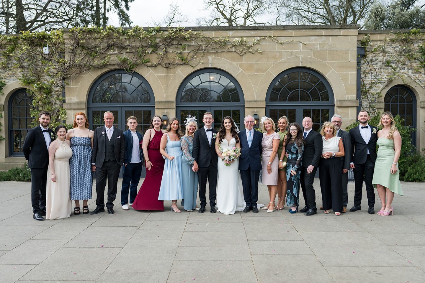 Wedding guests outside the stone buildings at Becky and Alex’s Middleton Lodge wedding