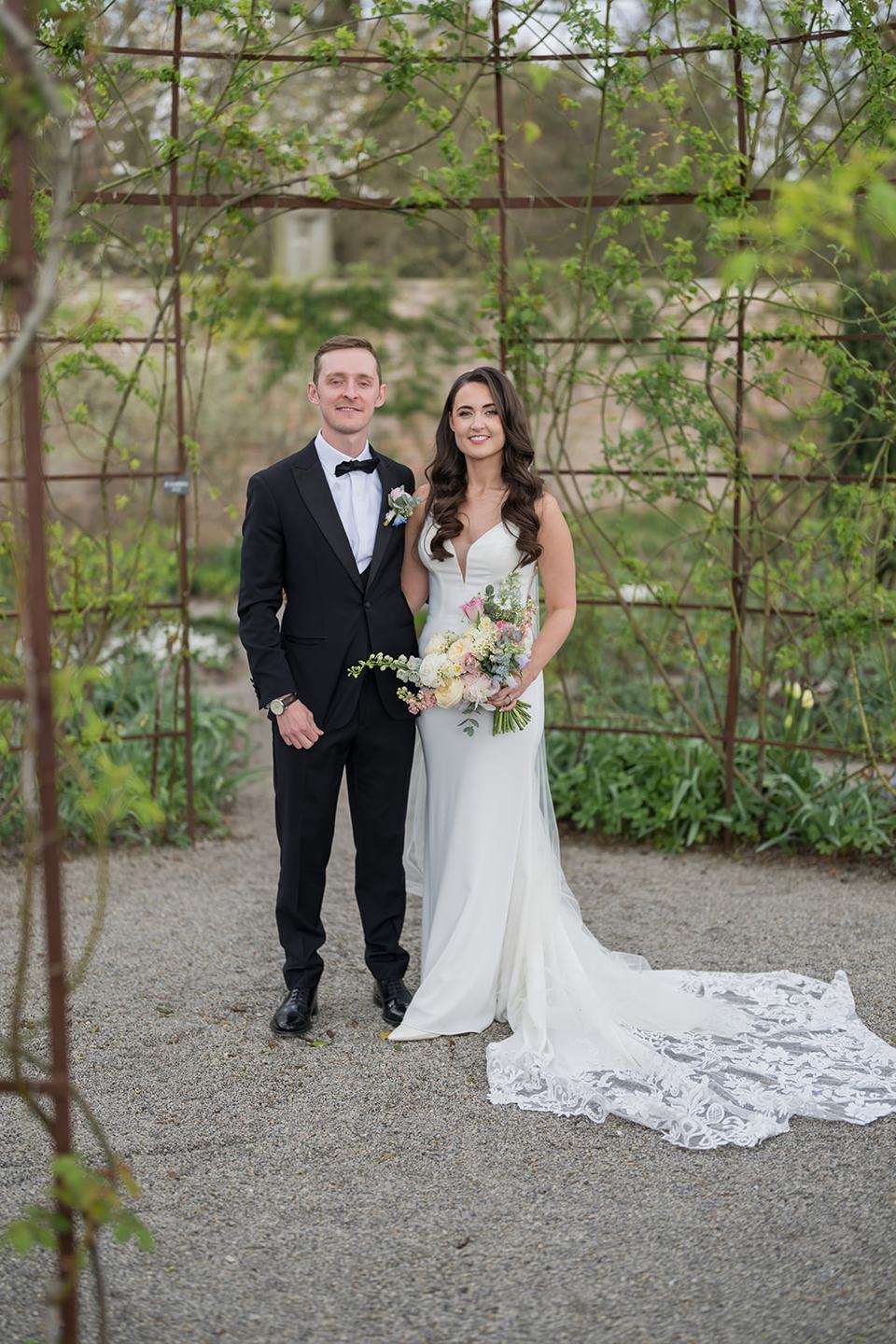 Couple beneath the garden trellis at Becky and Alex’s Middleton Lodge wedding