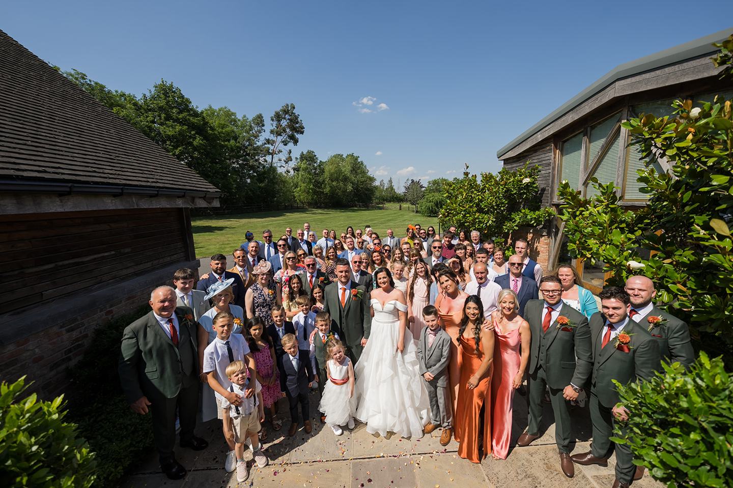 Wedding guests outside the barn at Kate and Kieran’s Mythe Barn wedding
