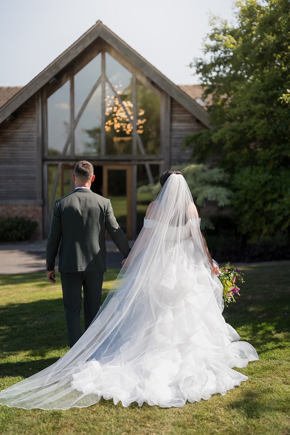 Couple in front of the barn at Kate and Kieran’s Mythe Barn wedding