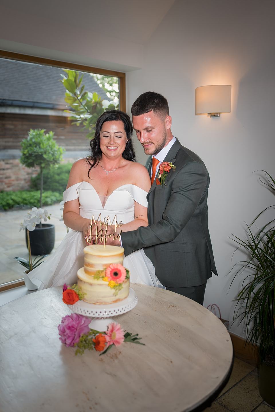 Cutting the wedding cake at Kate and Kieran’s Mythe Barn wedding