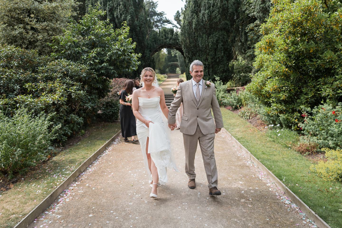 Bride arriving through the gardens at Kate and Jacob’s The Orangery at Ingestre wedding