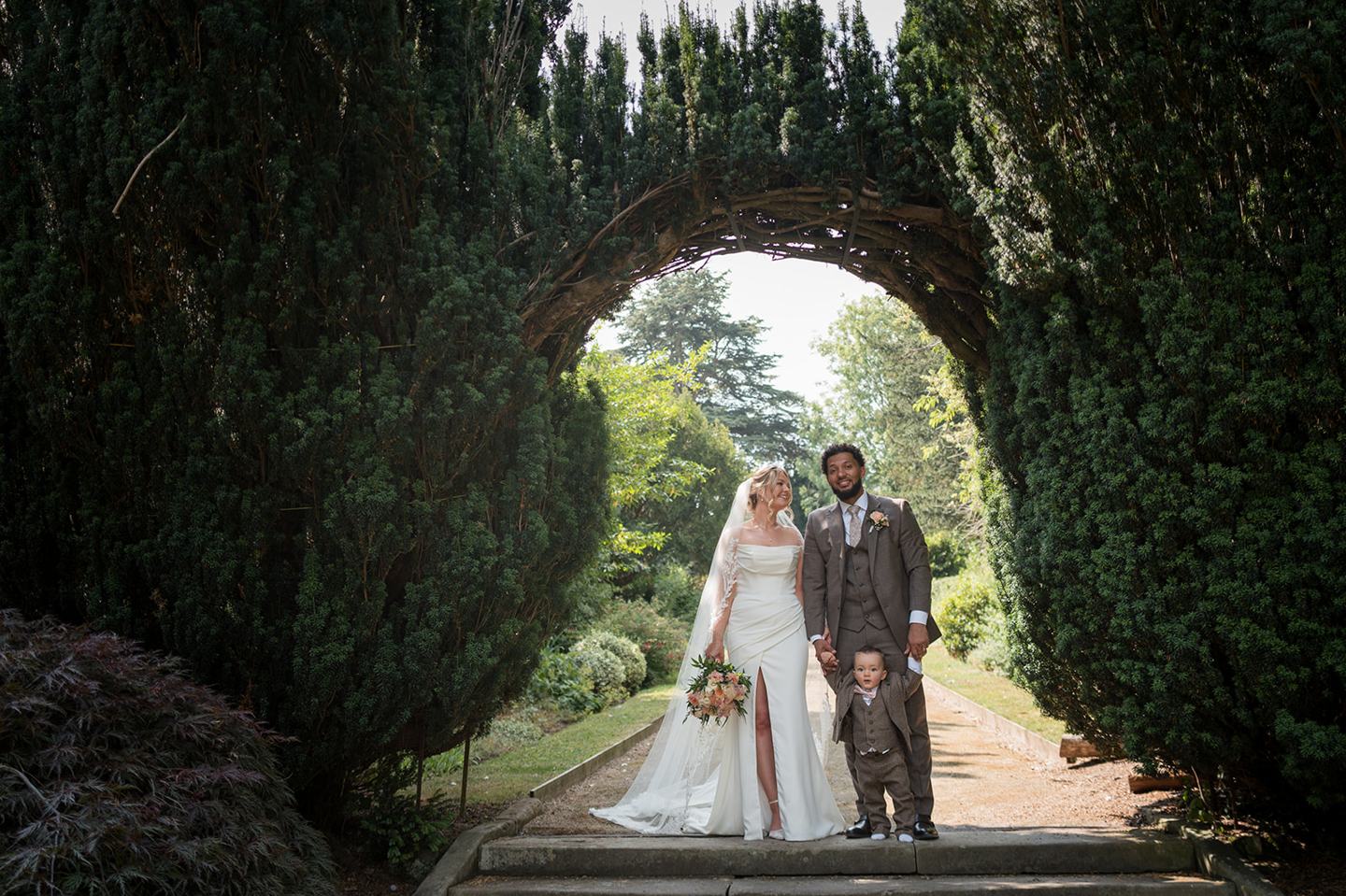 Couple beneath the garden arch at Kate and Jacob’s The Orangery at Ingestre wedding