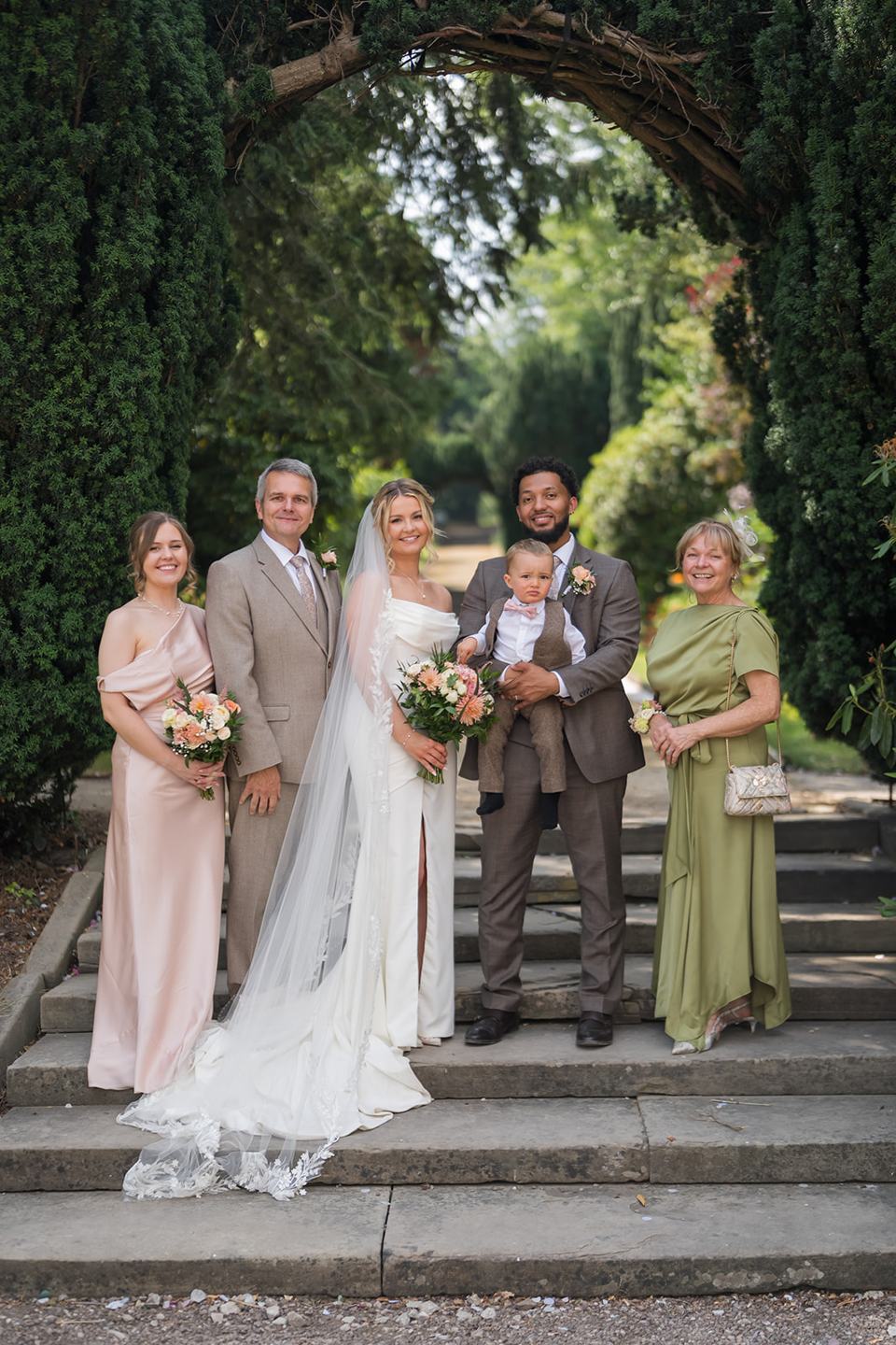 Family photographs beneath the garden arch at Kate and Jacob’s The Orangery at Ingestre wedding