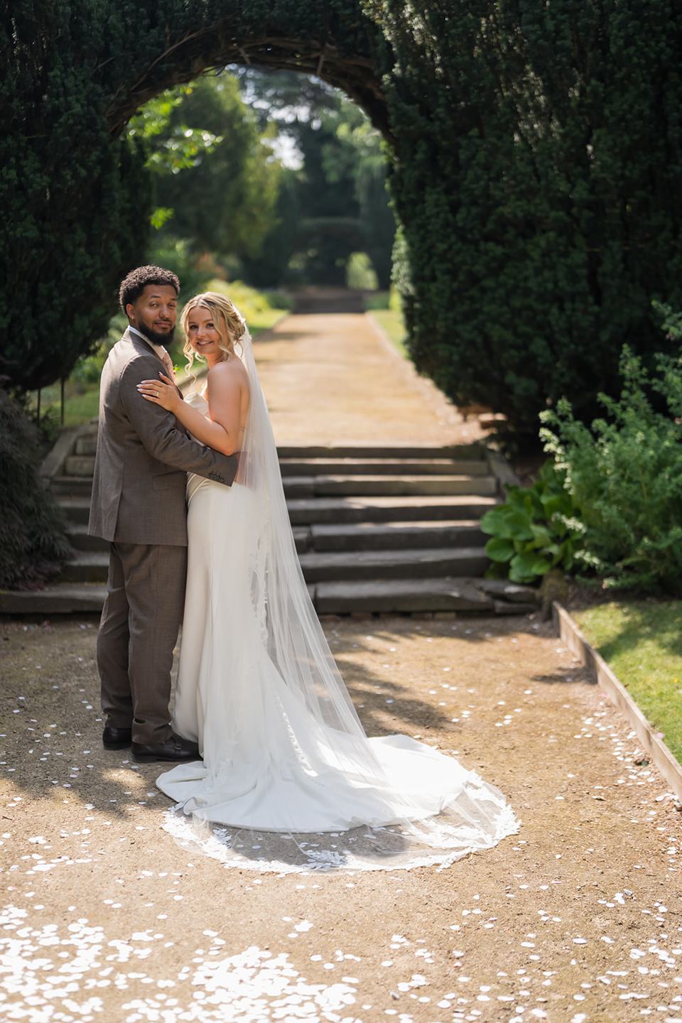 Newlyweds beneath the leafy arch at Kate and Jacob’s The Orangery at Ingestre wedding