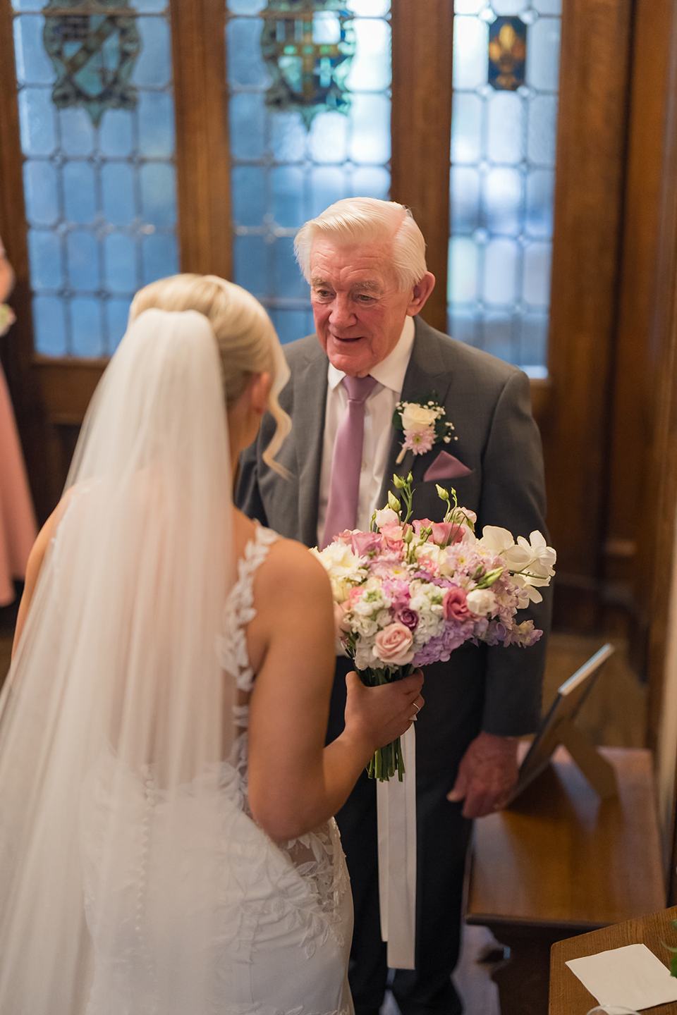 Bride greeting her father on the staircase at Samantha and Adam’s West Tower wedding