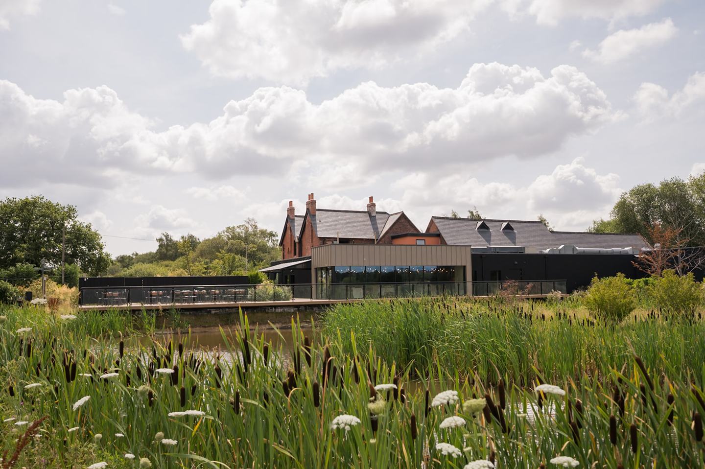 The venue beyond the water at Danielle and Joe’s The Whistle Barns wedding