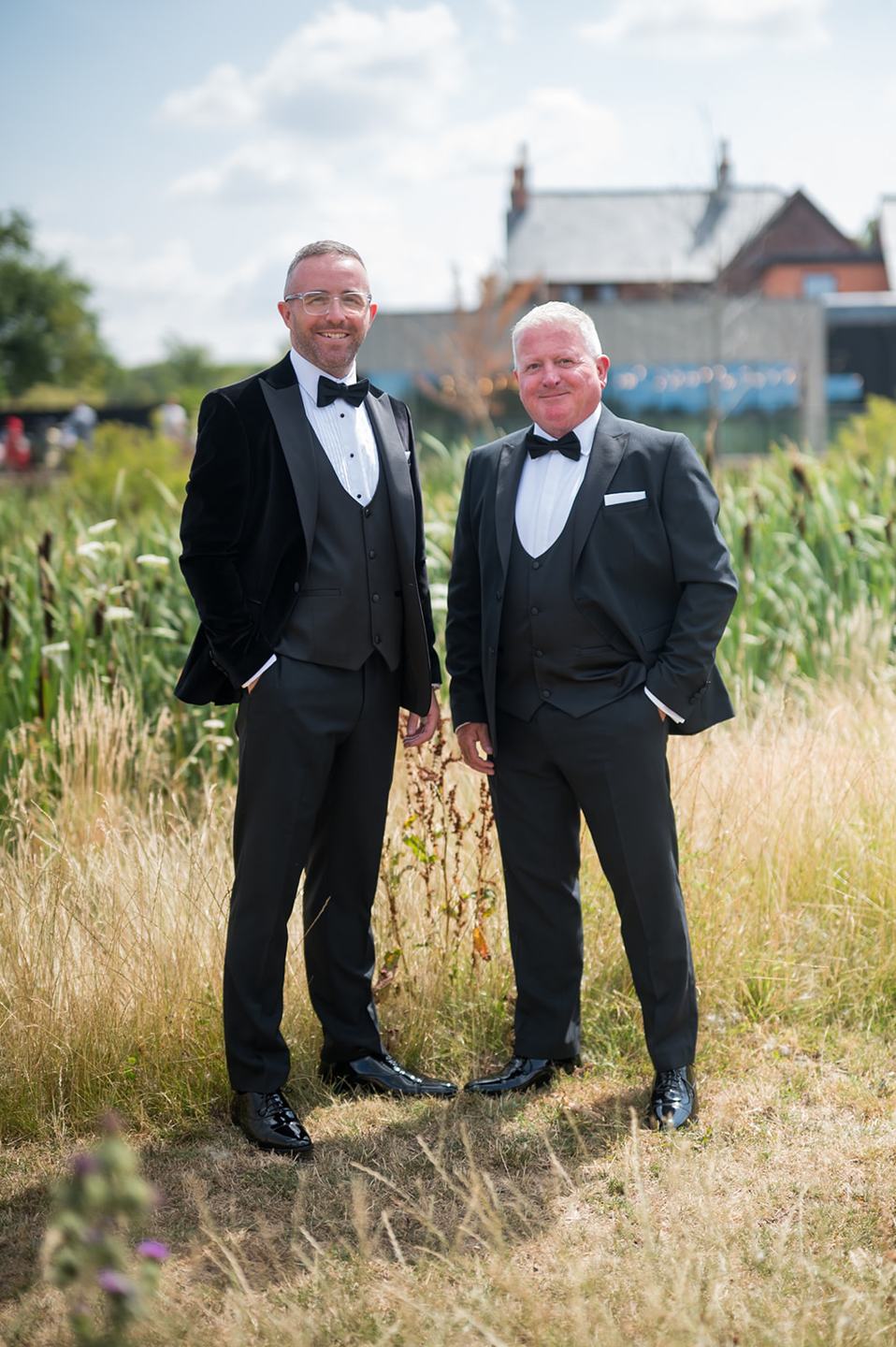 Groom with a guest in the grounds at Danielle and Joe’s The Whistle Barns wedding