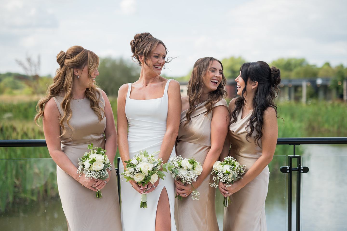 Bride and bridesmaids beside the water at Danielle and Joe’s The Whistle Barns wedding