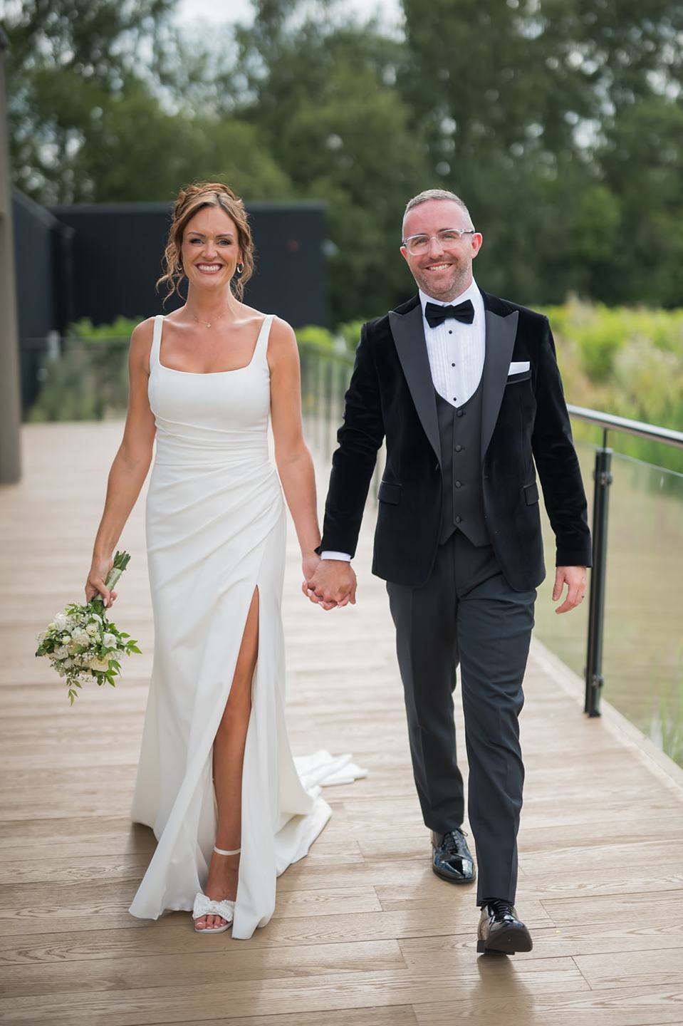 Newlyweds on the terrace at Danielle and Joe’s The Whistle Barns wedding