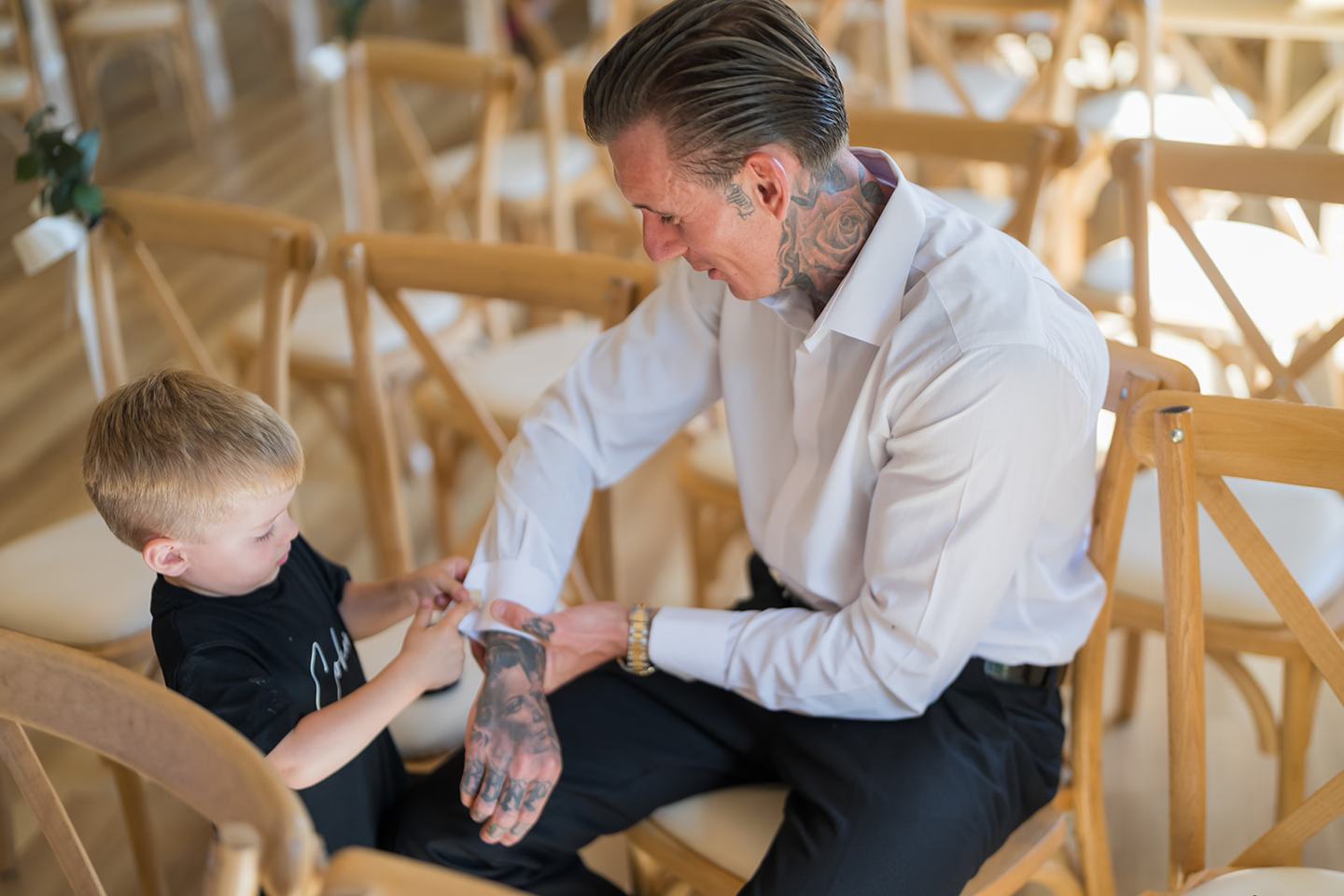 Groom helping a young wedding guest at Ellie and Thomas’s The Whistle Barns wedding