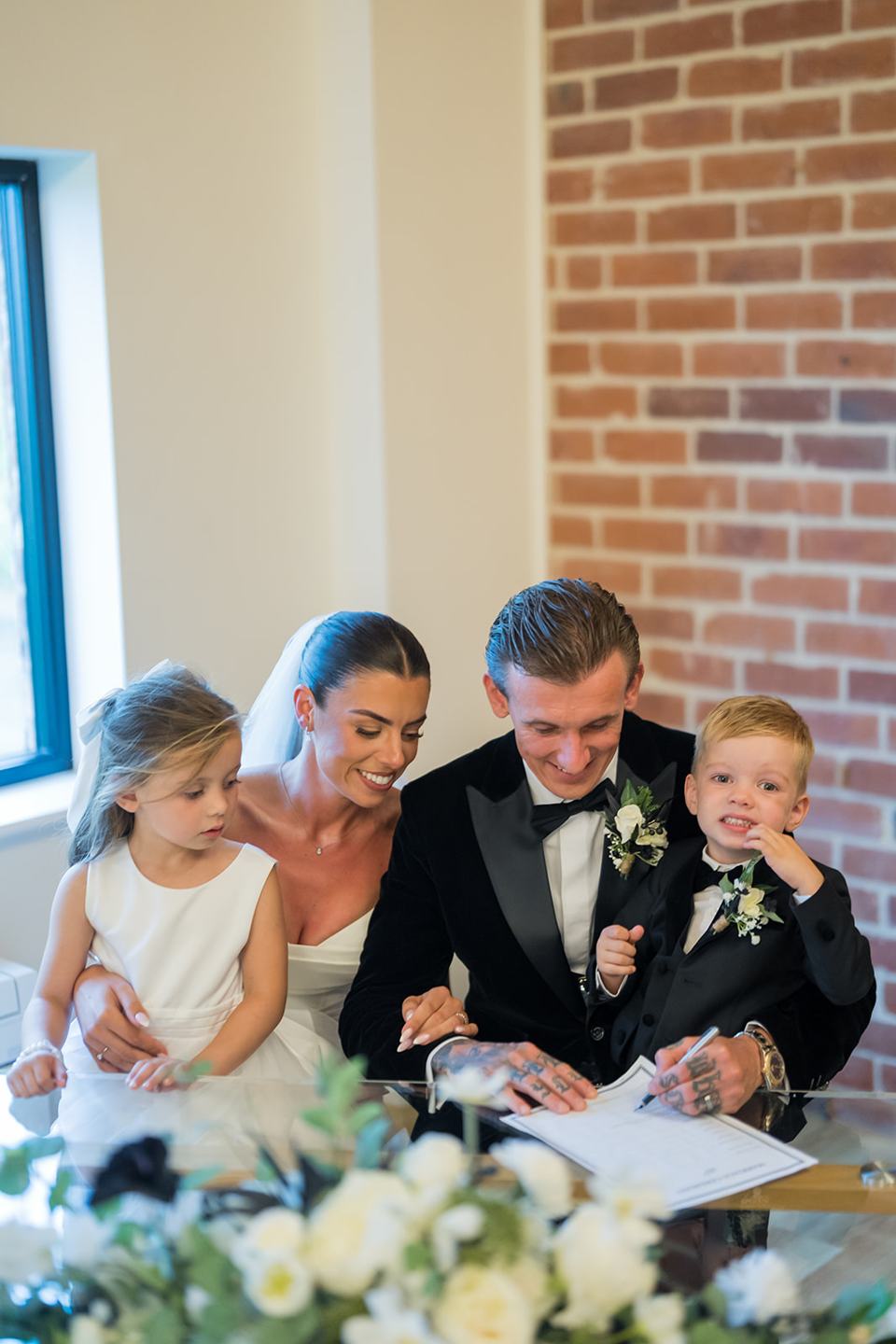 Signing the register with the children at Ellie and Thomas’s The Whistle Barns wedding