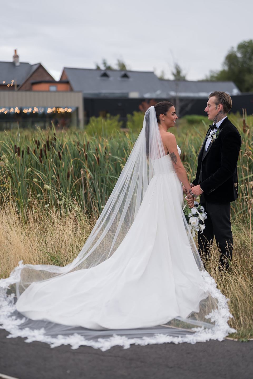 Couple portrait with the venue behind at Ellie and Thomas’s The Whistle Barns wedding
