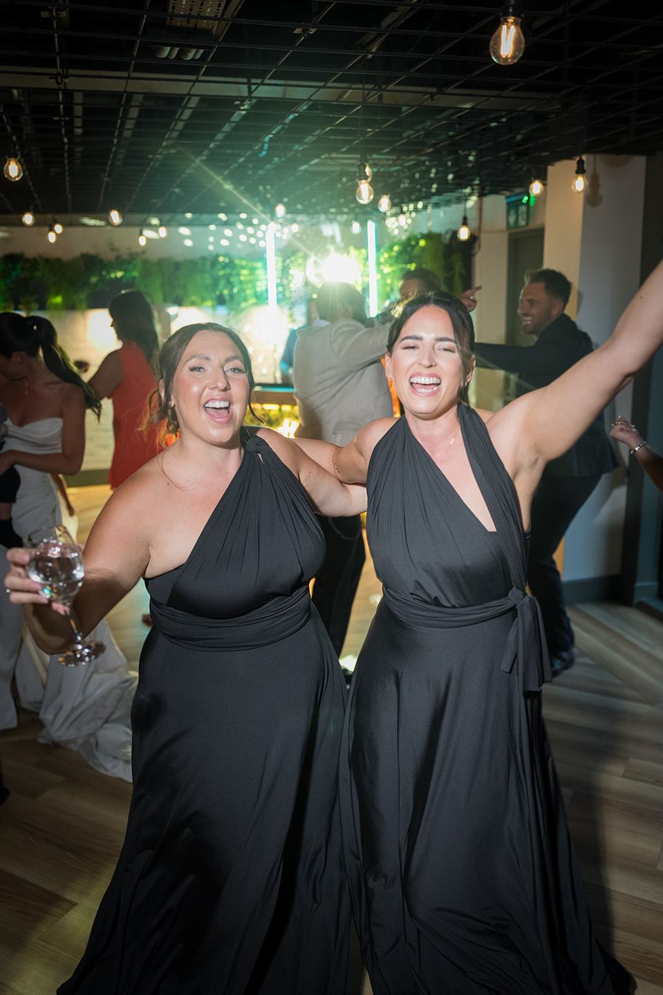 Guests celebrating on the dance floor at Ellie and Thomas’s The Whistle Barns wedding
