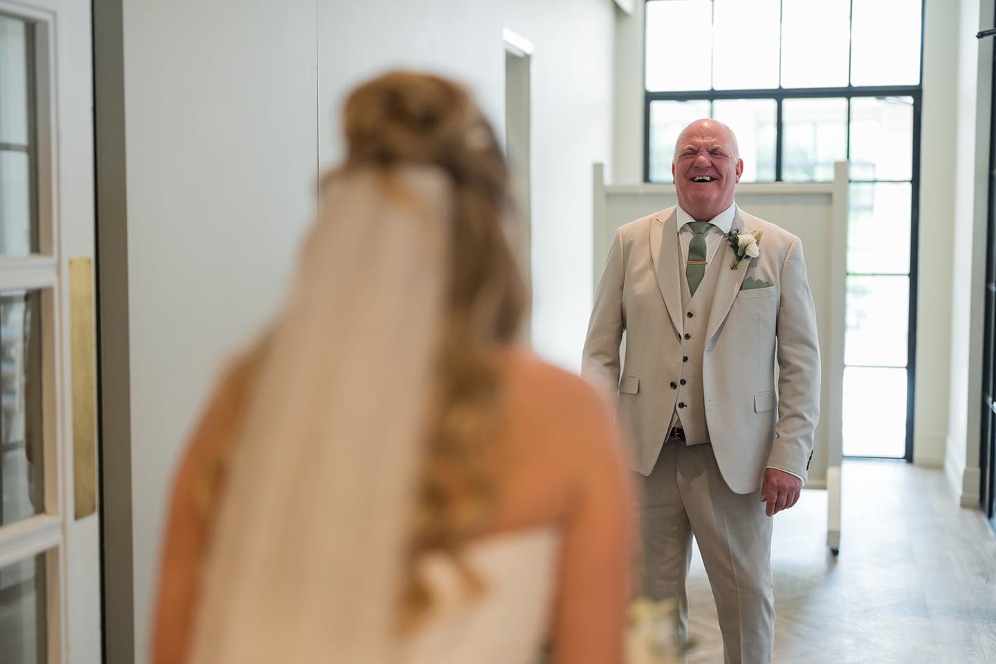Bride greeting her father at Chloe and James’s Woodlands Hotel wedding