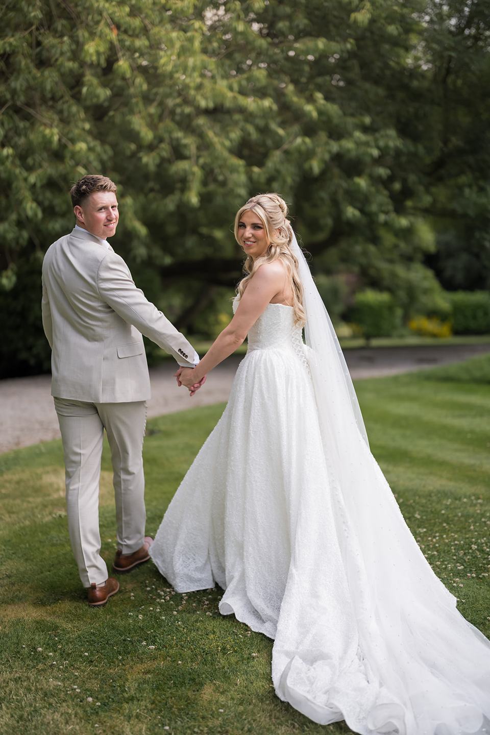 Newlyweds walking on the lawn at Chloe and James’s Woodlands Hotel wedding