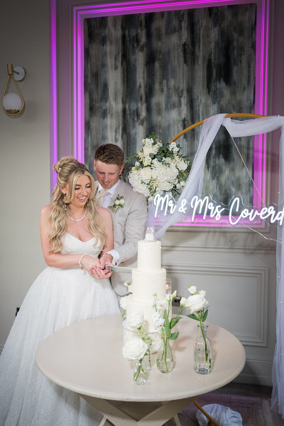 Cutting the wedding cake at Chloe and James’s Woodlands Hotel wedding