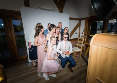 Guests enjoying a Manchester photo booth with props and instant photo printing at a celebration
